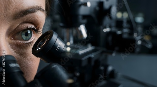 Scientist looking through a microscope in a laboratory for research