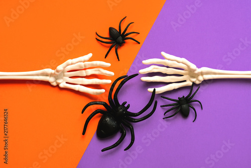 Top view of skeleton hand bones with Halloween spiders. Halloween concept background