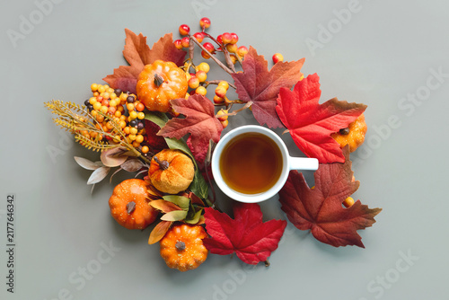 Top view of cup of tea with pumpkins and autumn leaves. Autumn concept background