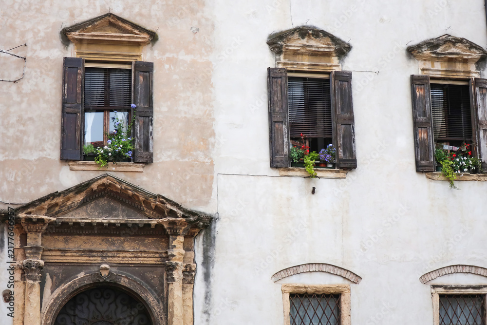 Obraz premium Picturesque old building facade in a European town, showcasing vintage architecture, stone molding, and rustic shutters.