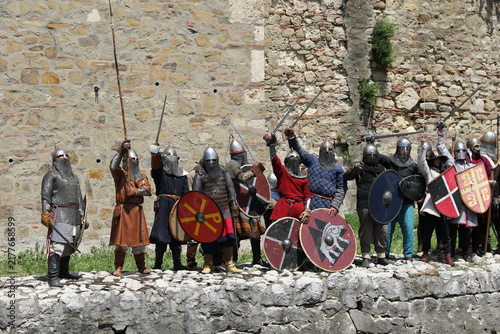 Photography Group of Medieval Knights Raising Weapons in Celebration Historical Reenactment