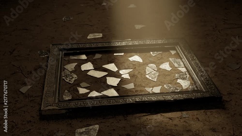Vintage picture frame with scattered glass shards laying on sandy soil