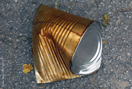 Принти на полотні A  heavily crushed and rusting metal can lies discarded on a rough asphalt surface