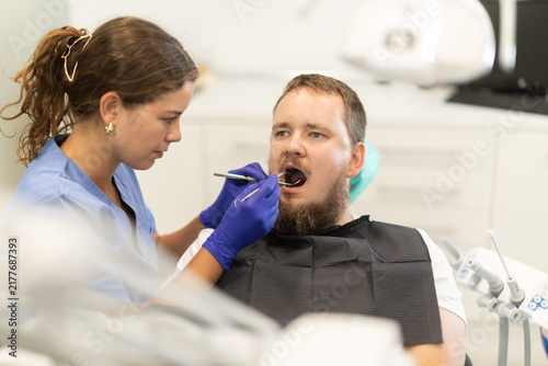 Bild auf Leinwand Man sits anxiously in a chair at a dentist appointment