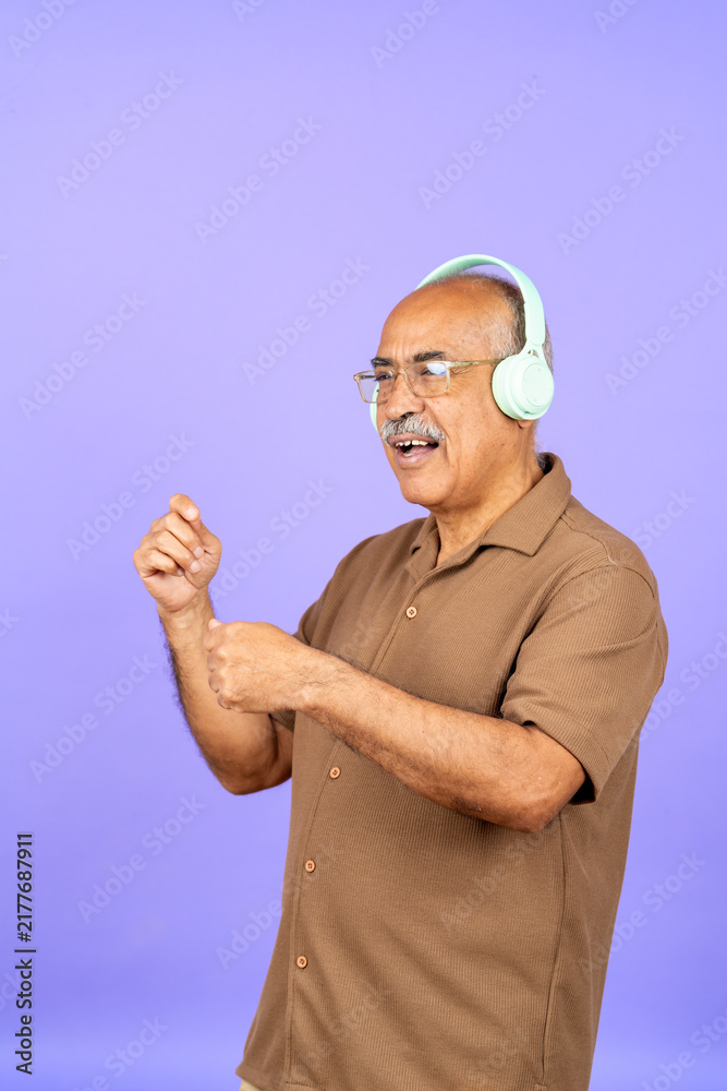 Fototapeta premium Senior man enjoying music with headphones dancing