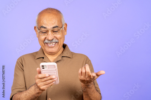 Happy older man interacting with smartphone device