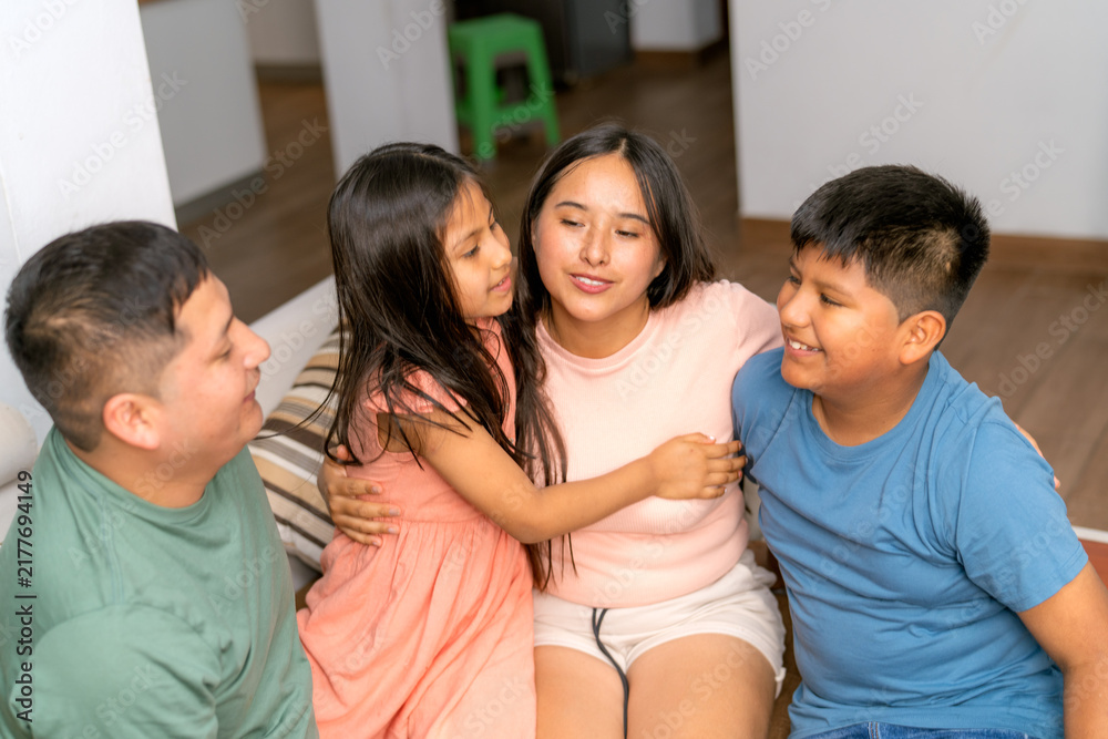 Fototapeta premium Young family enjoying happy moments hugging children