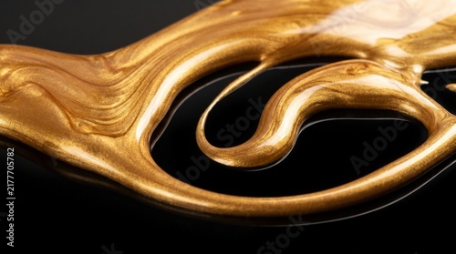 Abstract Close Up Macro of Metallic Liquid Gold Paint Swirling on Black Surface
