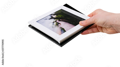 Фотография Isolated hand holding stacked white and black photo frames with a picture of feet