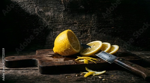 Fresh lemon sliced on rustic wooden cutting board