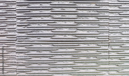 Картината върху платно Close-up of a gray cement plastered wall with evenly spaced horizontal grooved lines and rough surface texture, commonly used in construction and architectural facades