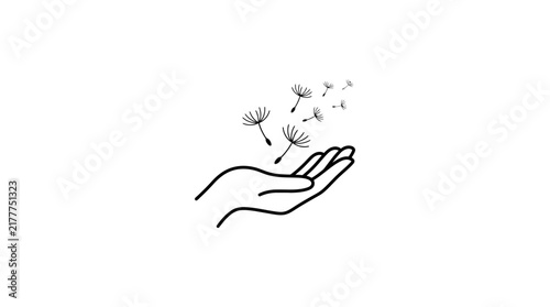 Hand releasing dandelion seeds into the air