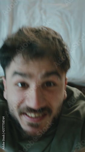 Man dancing energetically in bedroom looking at camera, funny morning mood ,vertical video
