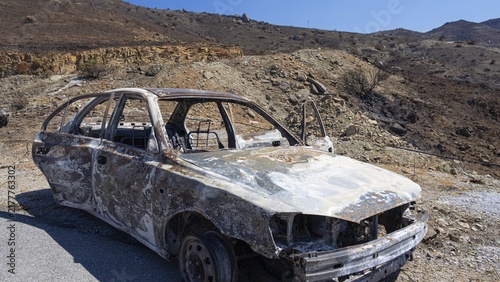 A rusty, burnt vehicle in a mountainous, barren environment, forest fire, fire damage, fire on July 29 and 30, 2026, Agios Pavlos, bay on the south coast, south coast, Retimnon province, Crete, Greek Islands, Greece