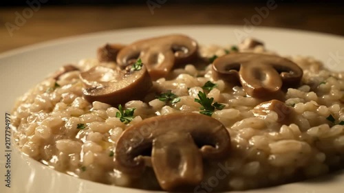 Creamy Mushroom Risotto or Orzotto Garnished with Parsley. Close-up of Gourmet Italian Comfort Food Served on a White Plate in a Rustic, Restaurant Setting.