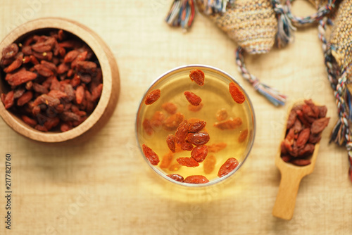 Canvastavla Goji berries in a glass of tea on a table