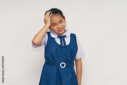 Confused Asian Schoolgirl in Blue Uniform Holding Head Isolated on White