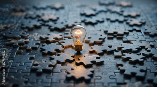 Plakat creative problem solving concept with glowing light bulb and puzzle pieces