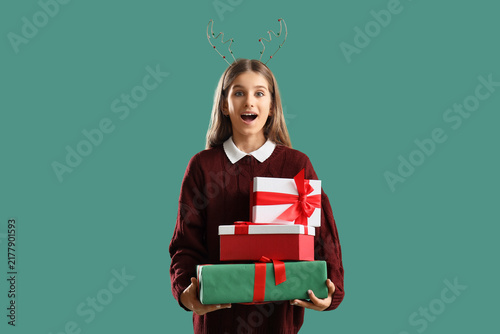 Quadro su tela Surprised teenage girl with Christmas gifts on green background