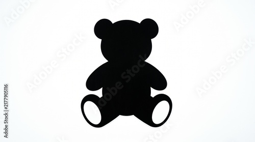 Black silhouette of a cute sitting teddy bear toy isolated on white background