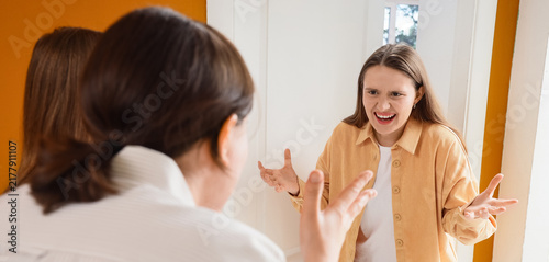 Фотография Interpersonal conflict and communication breakdown, angry woman shouting at frie