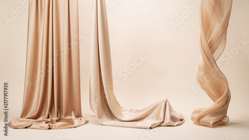 Flowing beige satin fabric drapes with soft folds and curves