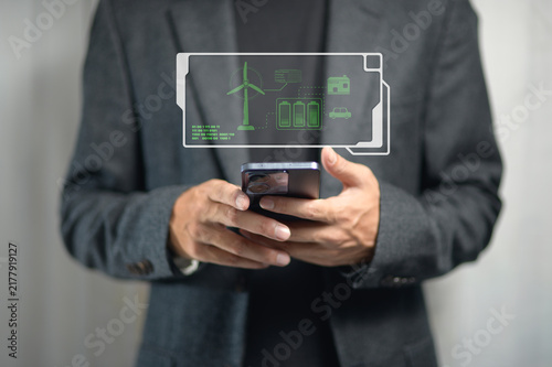 Business Professional Using Smartphone with Futuristic Wind Energy and Green Technology Interface