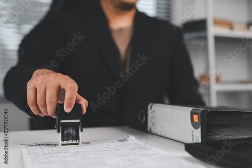 Business contract document stamping with approval seal, agreement verification, official paperwork process, legal compliance and corporate documentation concept.
