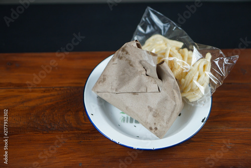 Obraz na plátne Indonesian traditional nasi bungkus wrapped in paper with crackers on enamel pla