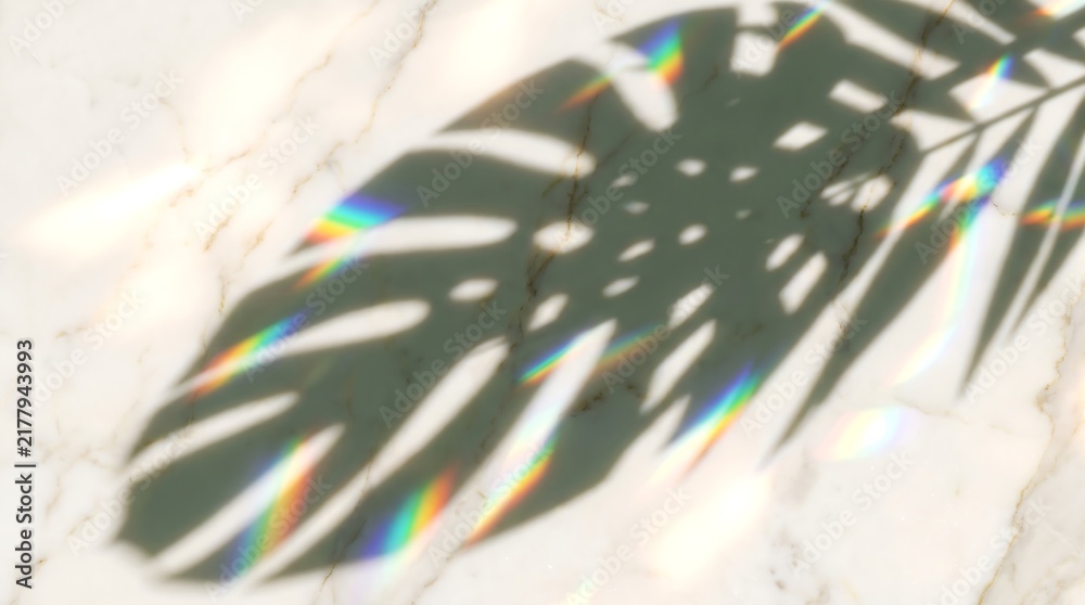 Obraz premium Abstract Monstera Leaf Shadow Overlaid with Prismatic Rainbow Light Reflections on a Textured White Marble Surface Background