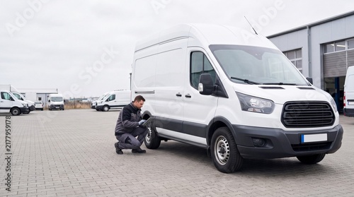 Automotive Specialist Evaluating Tire Condition on Delivery Van at Fleet Service Center