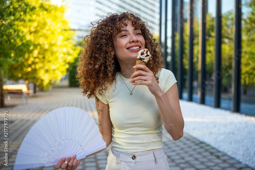 Foto Curly haired woman enjoying ice cream on a hot summer day