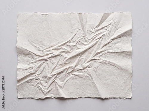 Crumpled white handmade paper with deckle edges, textured recycled parchment sheet, wrinkled organic cotton paper background