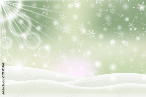 Winter christmas snow background with falling snowflakes, bright sunburst rays, glowing bokeh lights, and snowy hills on light green landscape backdrop