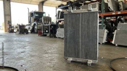 Industrial Radiator Component Standing in a Professional Truck Repair Workshop Featuring Precision Engineering and Metallic Cooling Systems for Heavy Vehicles
