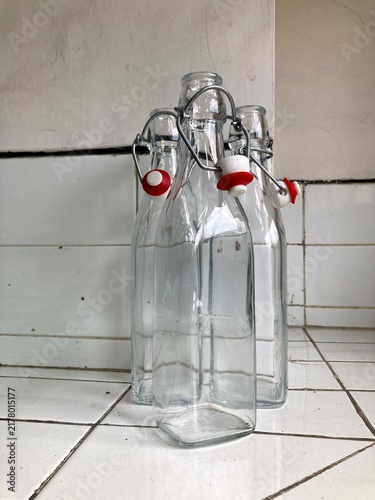 empty swing top glass bottles on white tiled counter