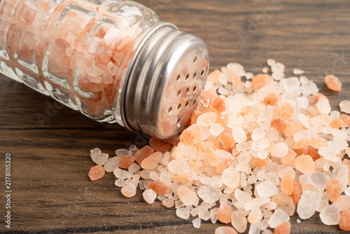 Fotografie Sodium chloride Himalayan pink salt with salt shaker.