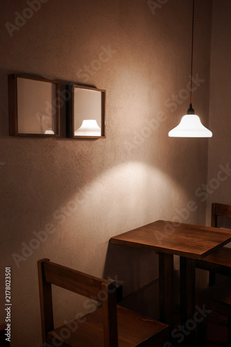 Chandelier and wooden tables and chairs in the corner of the old house cafe