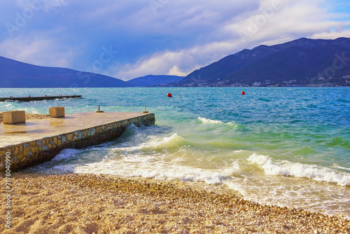  Beautiful winter Mediterranean landscape. Waves and empty beach. Montenegro, Tivat, view of Bay of Kotor