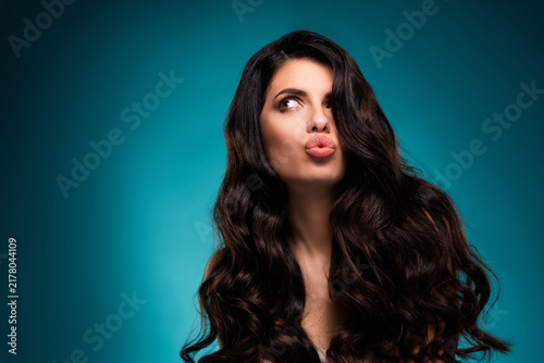 Принти на полотні Young glamorous woman with long brunette hair posing against teal background dis