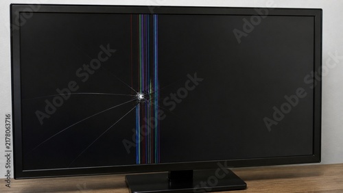 Broken LCD monitor screen with spider web cracks and dead pixels