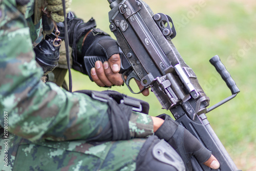 Fotografía Soldier in camouflage uniform holding a military assault rifle.