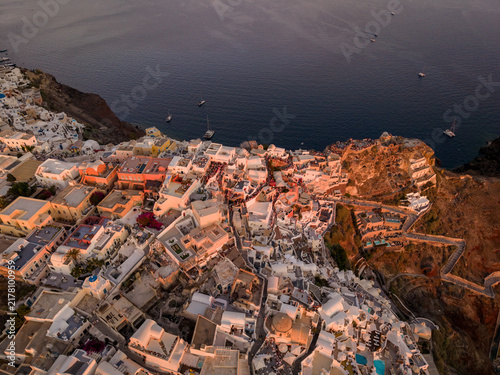 Foto High aerial drone perspective of cliffside Oia village, dark blue Aegean sea, an