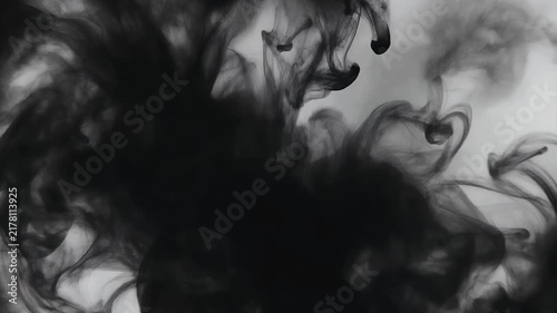 Abstract black ink dispersing in water, creating ethereal smoke-like patterns.