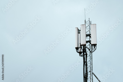 Obraz na płótnie Vertical telecommunications mast with antennas transmitting signals under a clou