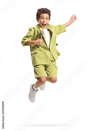 Fotografie Boy singing into a microphone and jumping