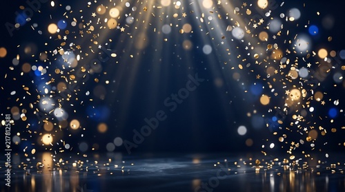 Golden confetti falling under bright stage spotlight beams.
