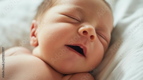 Slow motion close up of newborn baby yawning and breathing softly on linen bed in bright natural light at home