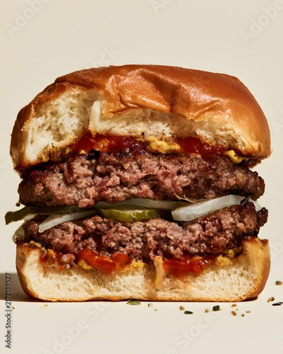 Half Cut Classic Burger Revealing Juicy Patty with Toppings and Sauce on a Soft Bun