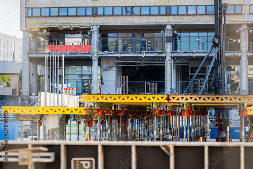 Foto Large building under renovation with concrete supports and temporary constructio